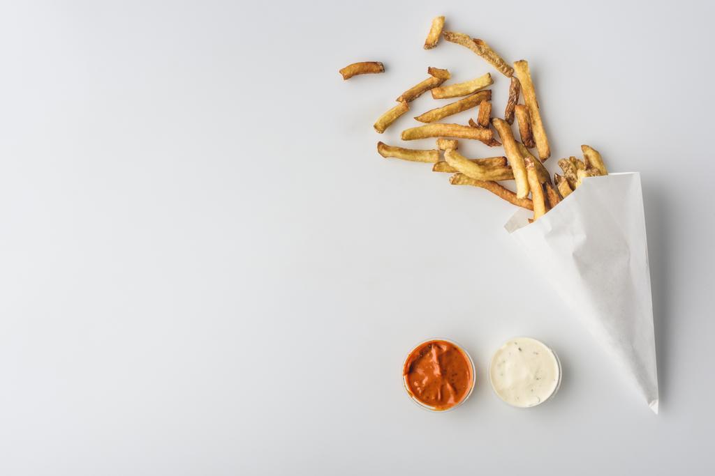 vue de dessus des frites en cône de papier, mayonnaise et sauces ketchup, isolées sur blanc
 - Photo, image