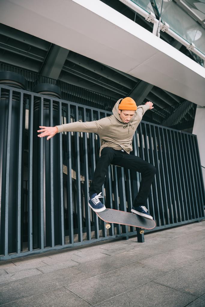 профессиональный скейтбордист, выполняющий трюк в городской местности
 - Фото, изображение