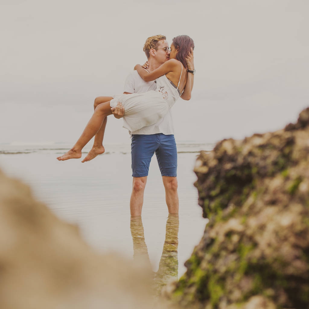 Nuori pari suutelee lähellä merta
 - Valokuva, kuva
