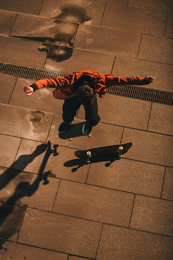 high angle view of skateboarder jumping over board - Photo, Image