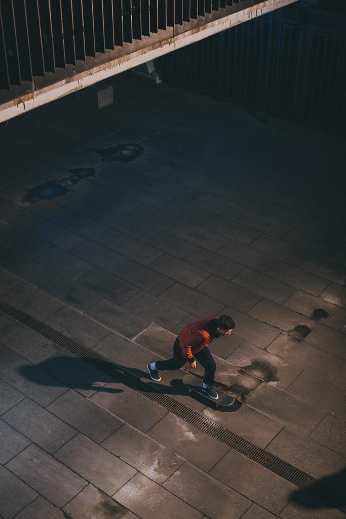 high angle view of skateboarder riding outdoors at late night - Photo, Image