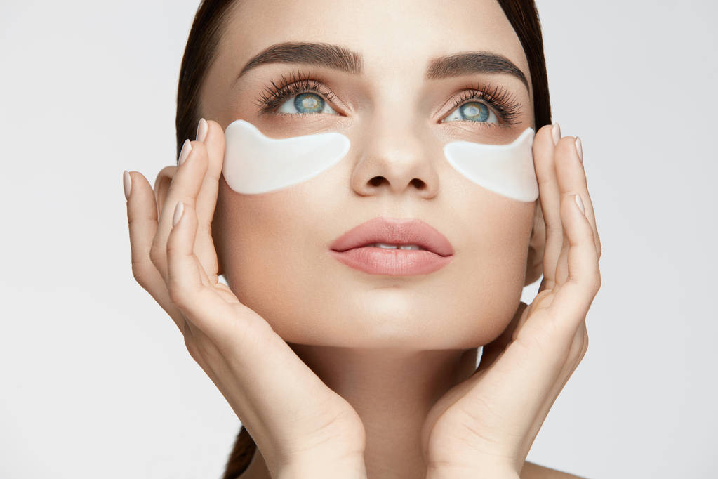Θεραπεία του δέρματος μάτι. Γυναίκα με λευκό υπό μάτι μπαλώματα στο πρόσωπο - Φωτογραφία, εικόνα