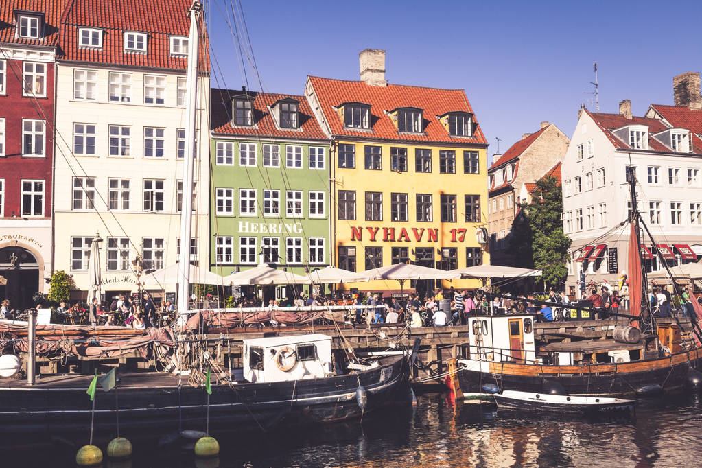 COPENHAGEN, DINAMARCA - 9 DE SEPTIEMBRE: personas en cafés abiertos del famoso paseo Nyhavn el 9 de septiembre de 2016 en Copenhague, Dinamarca. Nyhavn es uno de los monumentos más famosos de Copenhague
. - Foto, imagen