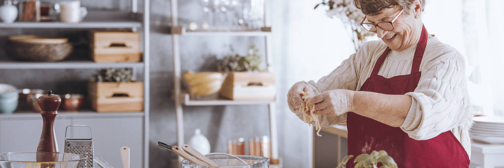 Femme âgée gaie préparant des pâtes
 - Photo, image