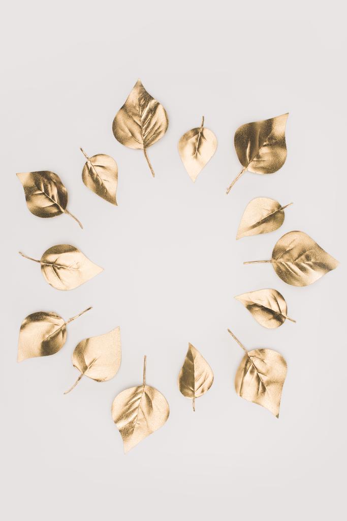 close up view of golden leaves arranged in circle isolated on grey - Photo, Image
