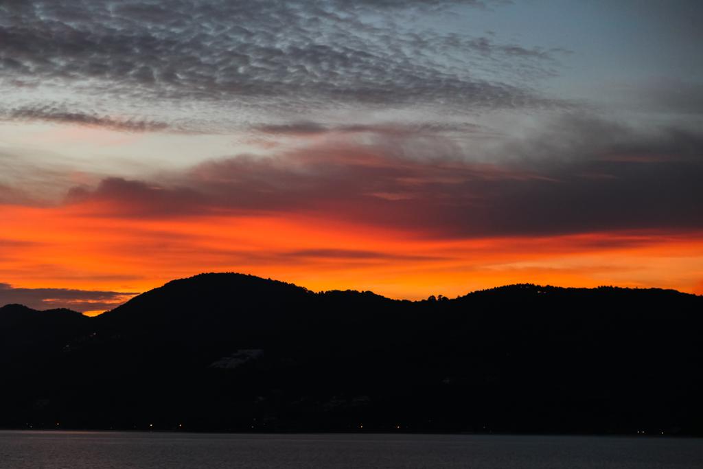 silhueta de colinas pretas abaixo do céu de pôr-do-sol laranja
 - Foto, Imagem