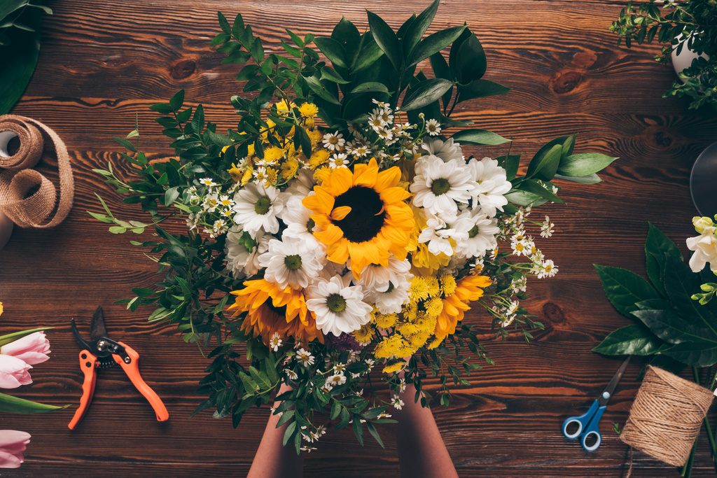 imagem cortada de florista colocando buquê de flores na mesa
 - Foto, Imagem
