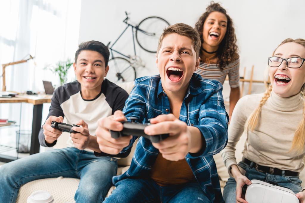 směje se multikulturní dospívající hrát videohry - Fotografie, Obrázek