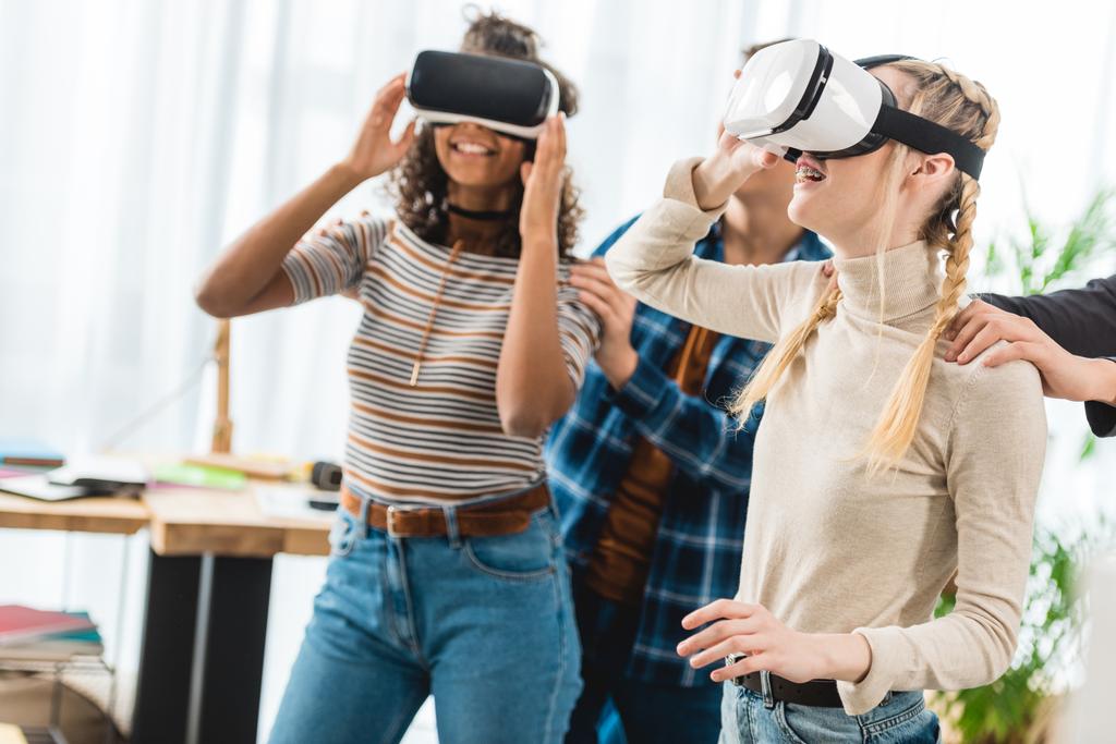 happy multicultural teen girls watching something with virtual reality headsets  - Photo, Image