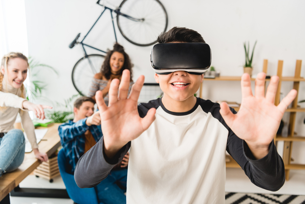 aufgeregter Teenager berührt etwas mit Virtual-Reality-Headset  - Foto, Bild