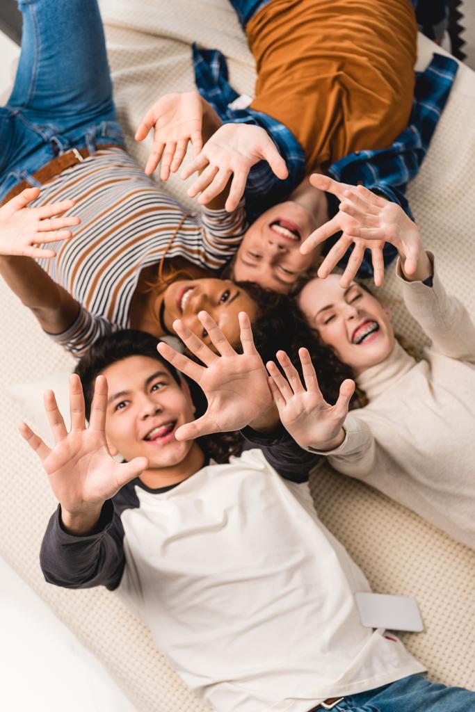 vista aérea de adolescentes multiétnicos sonrientes saludando con las manos
 - Foto, Imagen