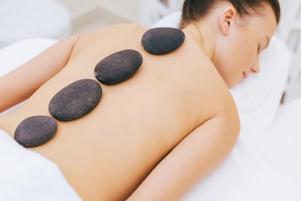 primo piano di una donna che fa la terapia con la pietra al salone spa
 - Foto, immagini