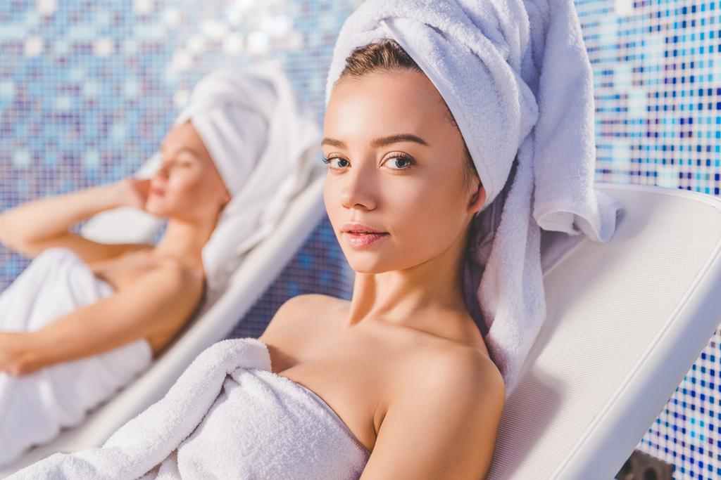 Nuoret naiset rentoutua aurinkotuoleja kylpylä keskus
 - Valokuva, kuva