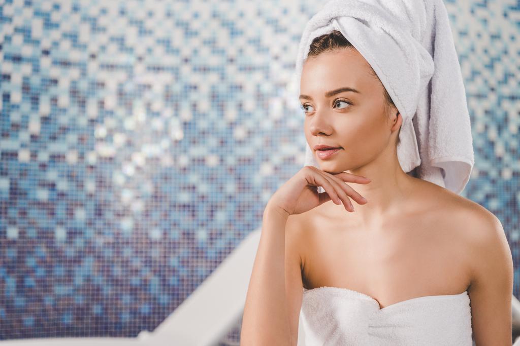 jeune femme réfléchie avec serviette sur la tête au salon de spa
 - Photo, image