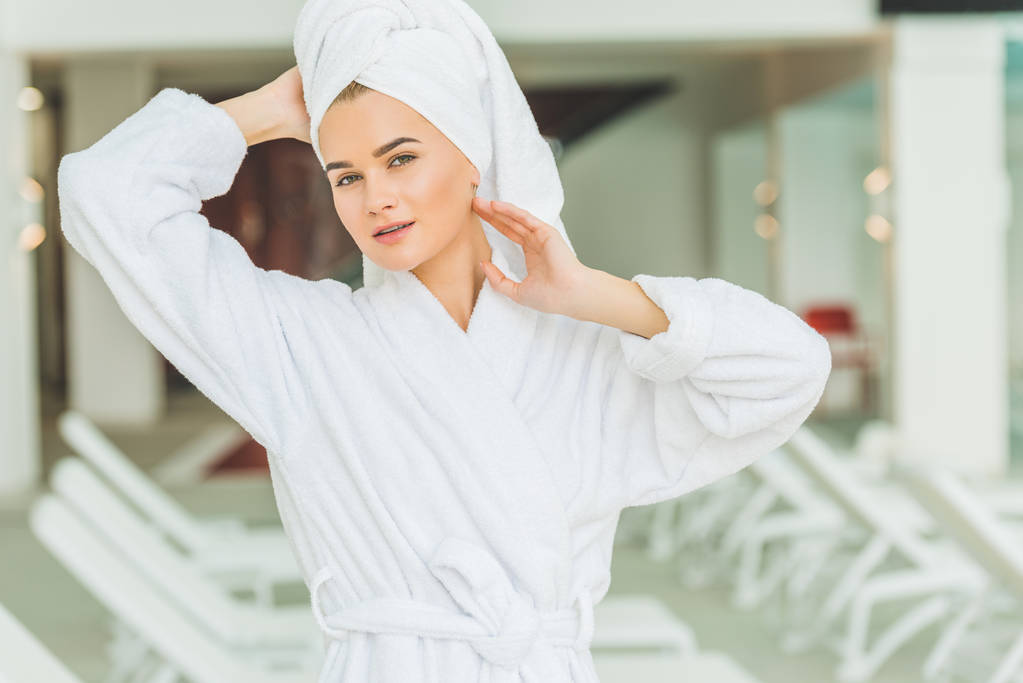 aantrekkelijke jonge vrouw in badjas en handdoek op hoofd op spa salon - Foto, afbeelding