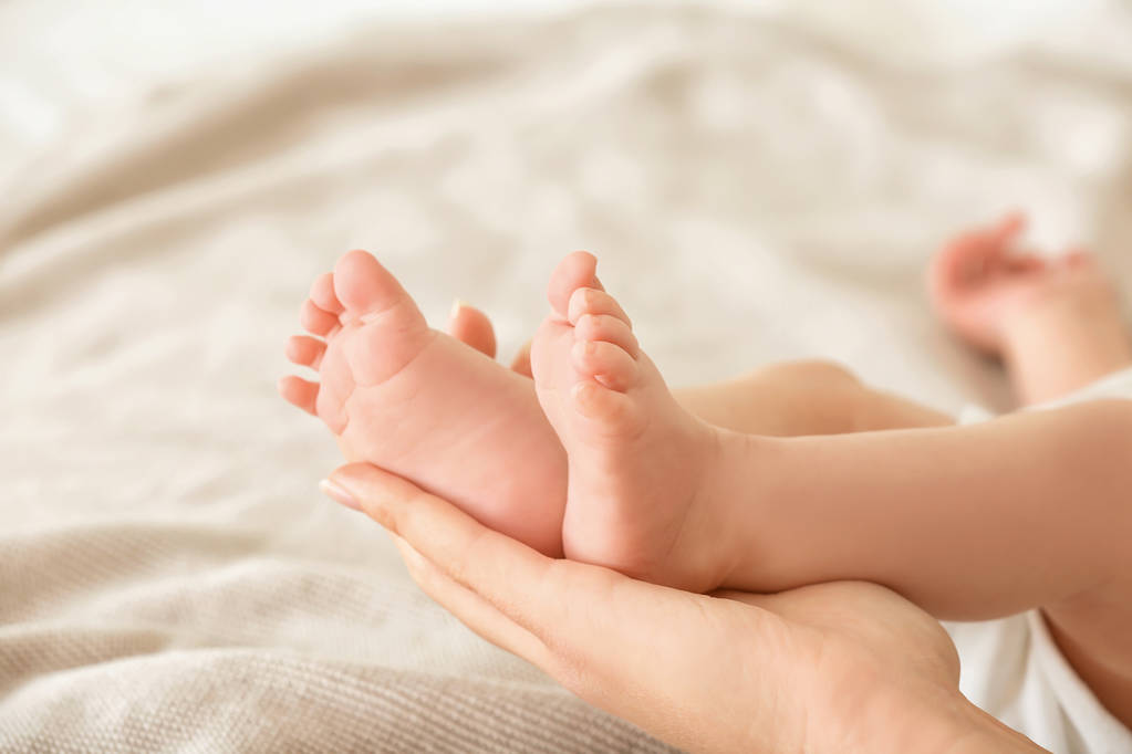madre sosteniendo pies de bebé  - Foto, imagen