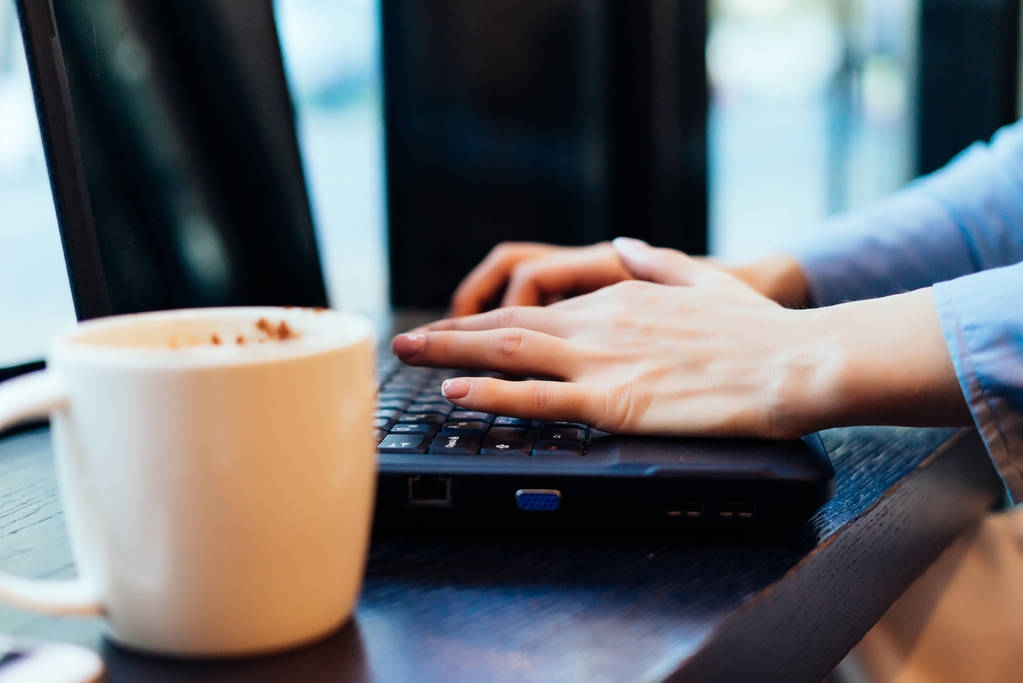 дівчина фрілансер, що працює в кафе для ноутбука, поруч з чашкою з ароматною кавою
 - Фото, зображення