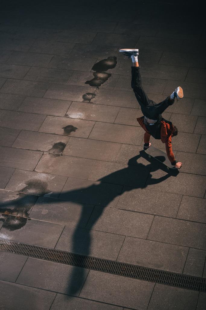 pohled z vysokého úhlu skateboardista jízda vzhůru nohama na rukou - Fotografie, Obrázek