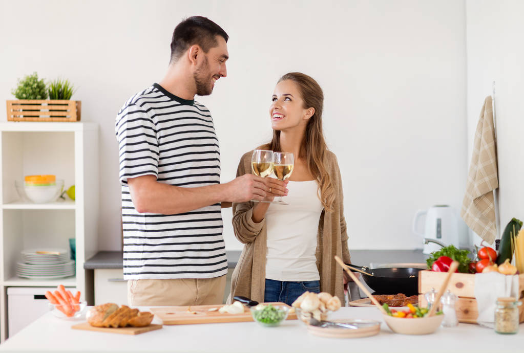 pareja cocinar alimentos y beber vino en casa
 - Foto, Imagen