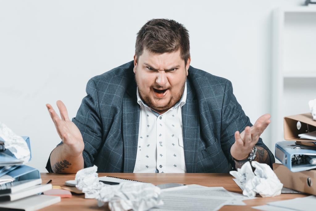 homem de negócios com excesso de peso irritado em terno trabalhando com documentos no escritório
 - Foto, Imagem