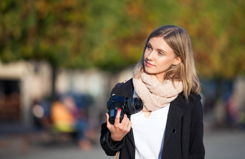 Menina com câmera andando na rua da cidade e olhando para algo
 - Foto, Imagem