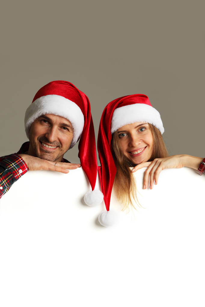 Paar in Weihnachtsmützen mit Banner - Foto, Bild