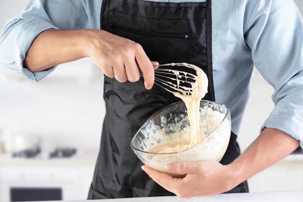 Un cocinero con huevos en una cocina rústica sobre el fondo de las manos de los hombres
 - Foto, Imagen