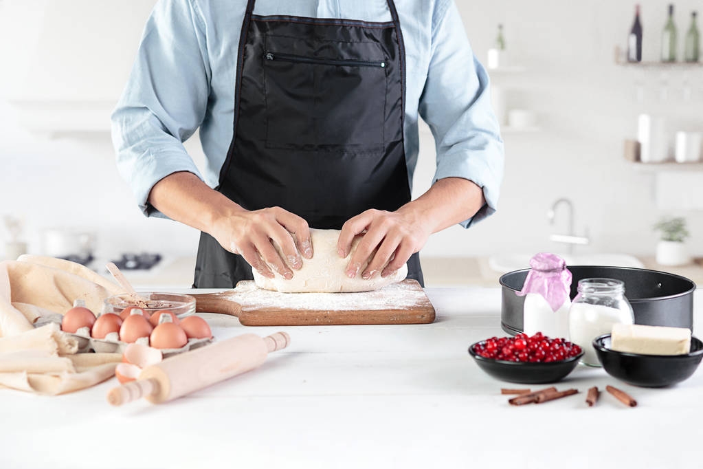 Un cuisinier avec des œufs sur une cuisine rustique sur fond de mains masculines
 - Photo, image
