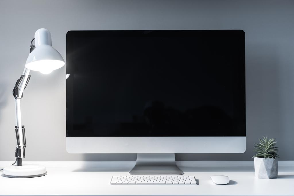 local de trabalho com computador e ligado à luz de mesa
 - Foto, Imagem