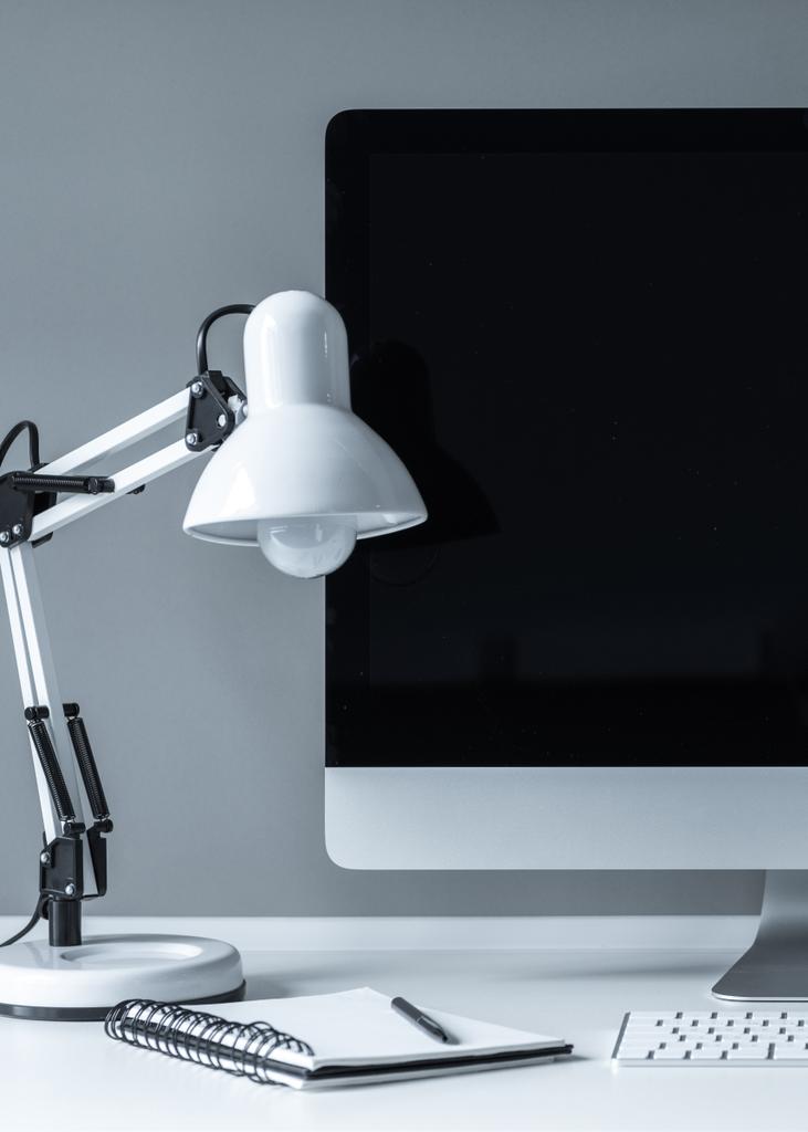 weiße Tischlampe und Computer mit schwarzem Bildschirm - Foto, Bild