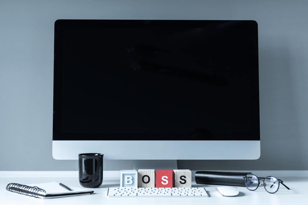 υπολογιστή και ξύλινων κύβων με λέξη αφεντικό σε λευκά επιτραπέζια - Φωτογραφία, εικόνα