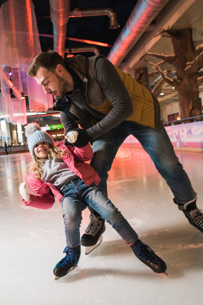 かわいい小さな娘のスケート リンクでスケートを教える父 - 写真・画像