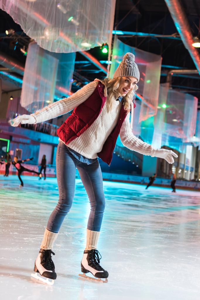 izgatott a gyönyörű fiatal nő korcsolyázás a jégpálya - Fotó, kép
