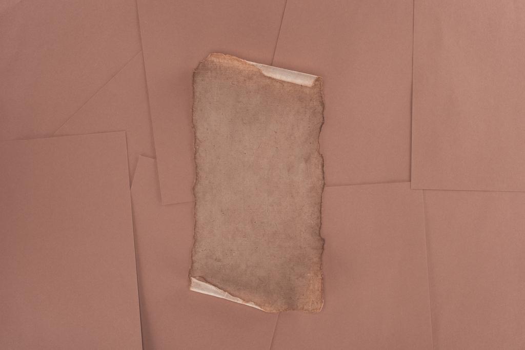 верхний вид старой поврежденной бумаги на фоне коричневой бумаги
 - Фото, изображение