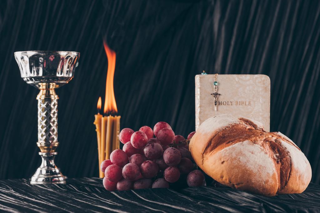 Αγία Γραφή, επιφάνεια και χριστιανικό σταυρό με κεριά στο σκοτεινό τραπέζι κοινωνήσω  - Φωτογραφία, εικόνα