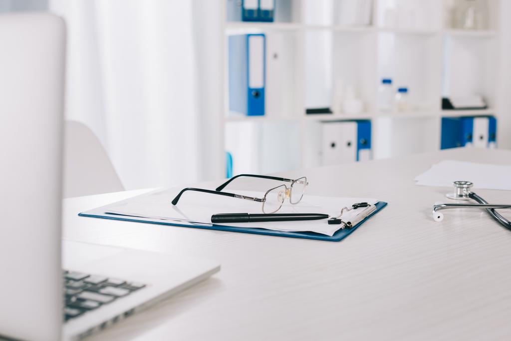 окуляри і ручка на кишені на робочому столі в клініці
 - Фото, зображення