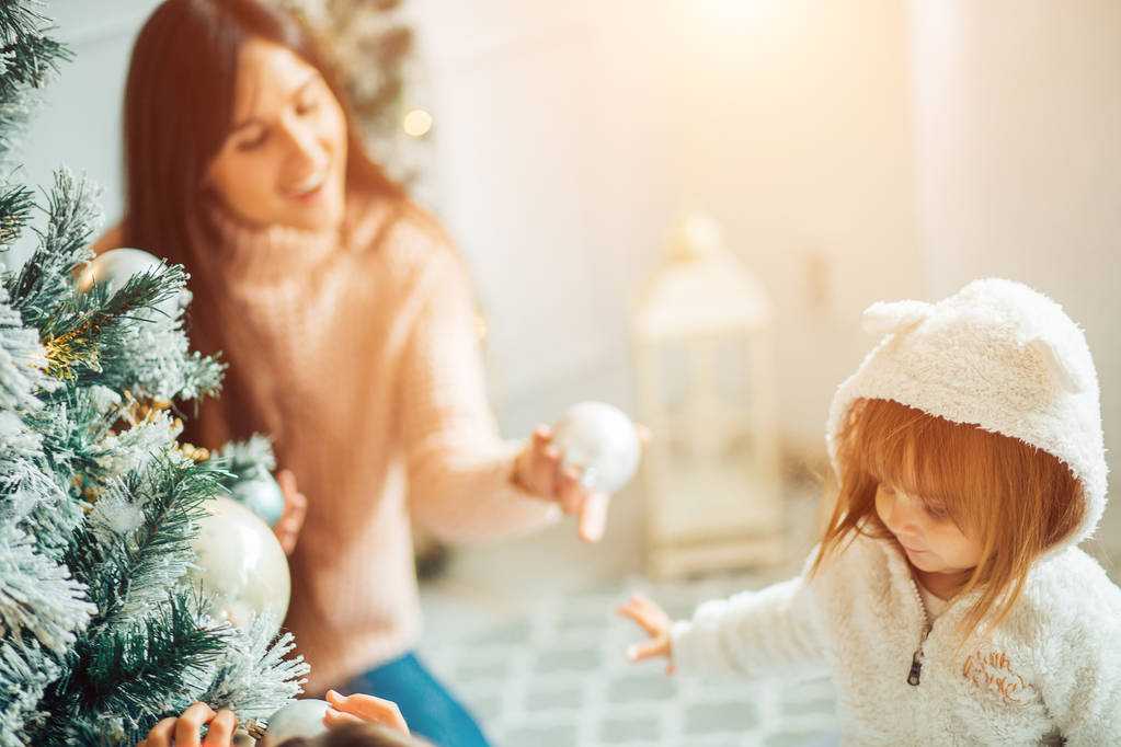 Mamma e figlia decorano l'albero di Natale al chiuso
 - Foto, immagini