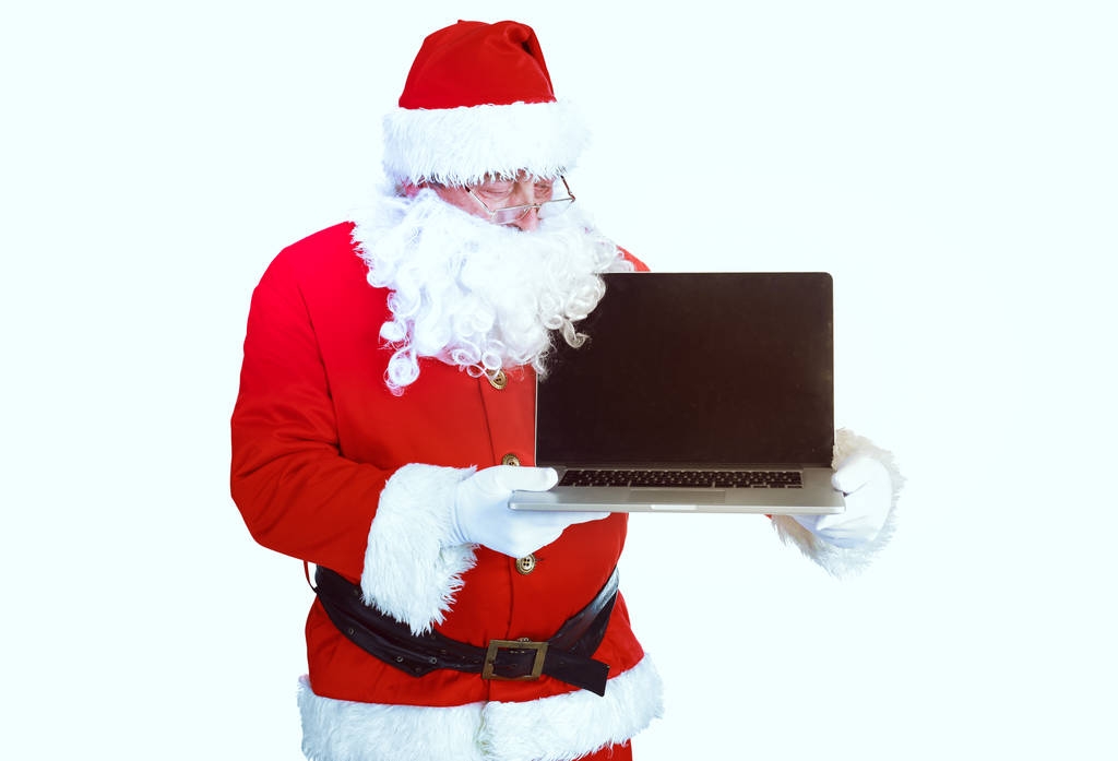 Weihnachtsmann präsentiert Laptop auf weißem Hintergrund - Foto, Bild