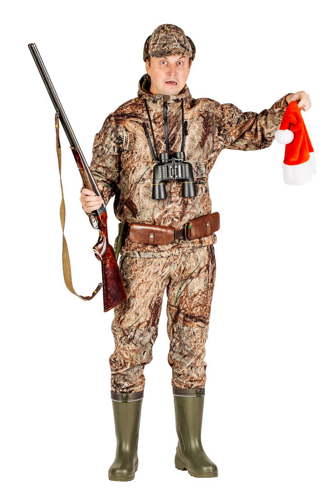 cazador masculino con escopeta de doble cañón sosteniendo sombrero de santa
 - Foto, imagen