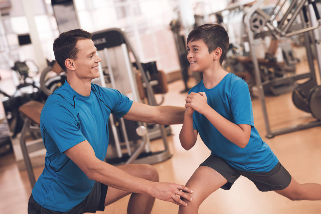 Vader en zoon in dezelfde kleren in de sportschool. Vader en zoon leiden een gezonde levensstijl. - Foto, afbeelding