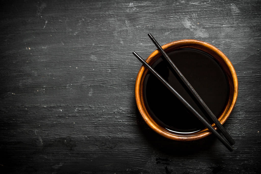 Soy sauce in a bowl and chopsticks. - Photo, Image