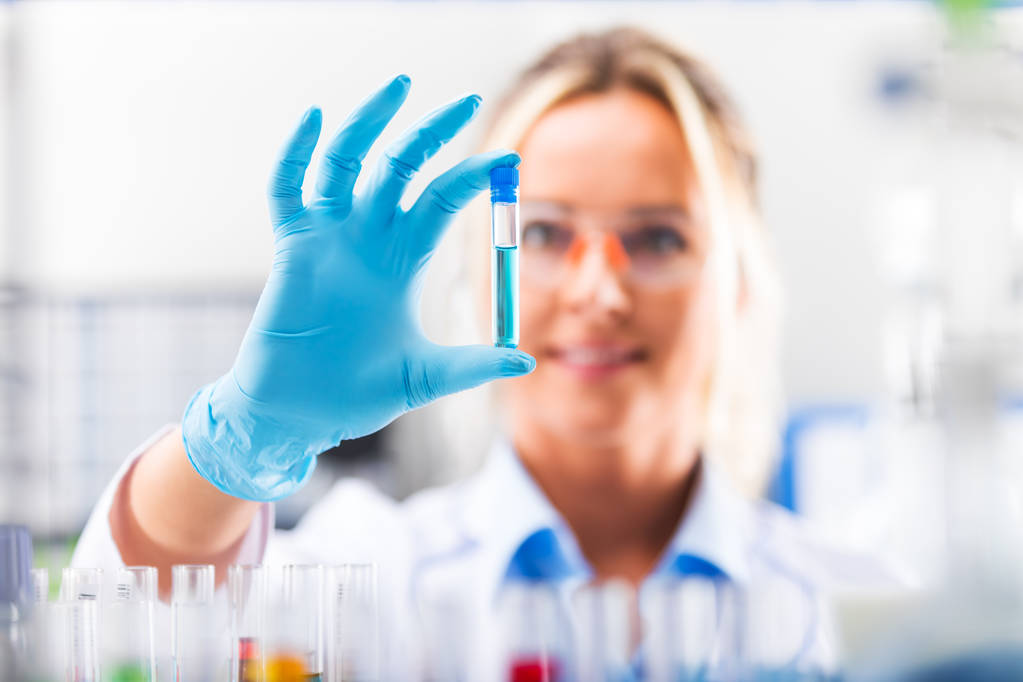Young attractive female scientist examining test tube with subst - Photo, Image