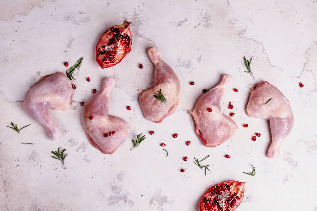 Patas de pollo crudas con granada preparadas para cocinar
 - Foto, imagen