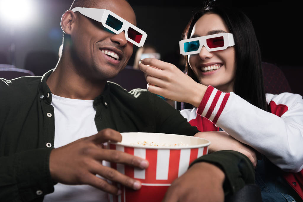映画館で映画を見ながらポップコーンを食べて 3 d メガネで異人種間のカップル - 写真・画像