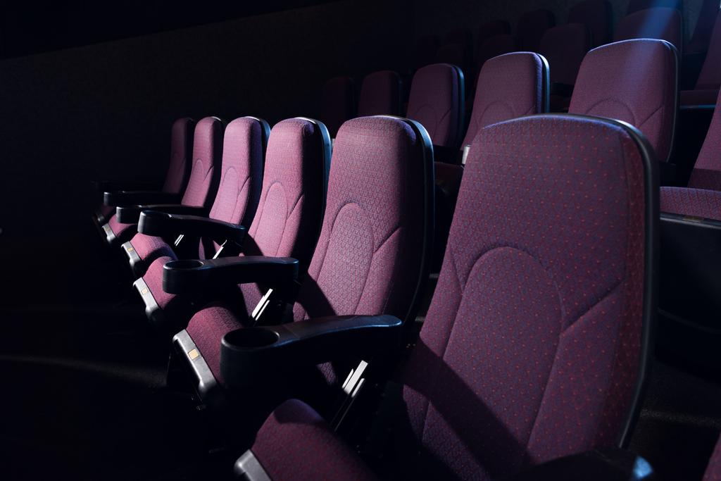 червоні сидіння в порожньому темному кінотеатрі
 - Фото, зображення