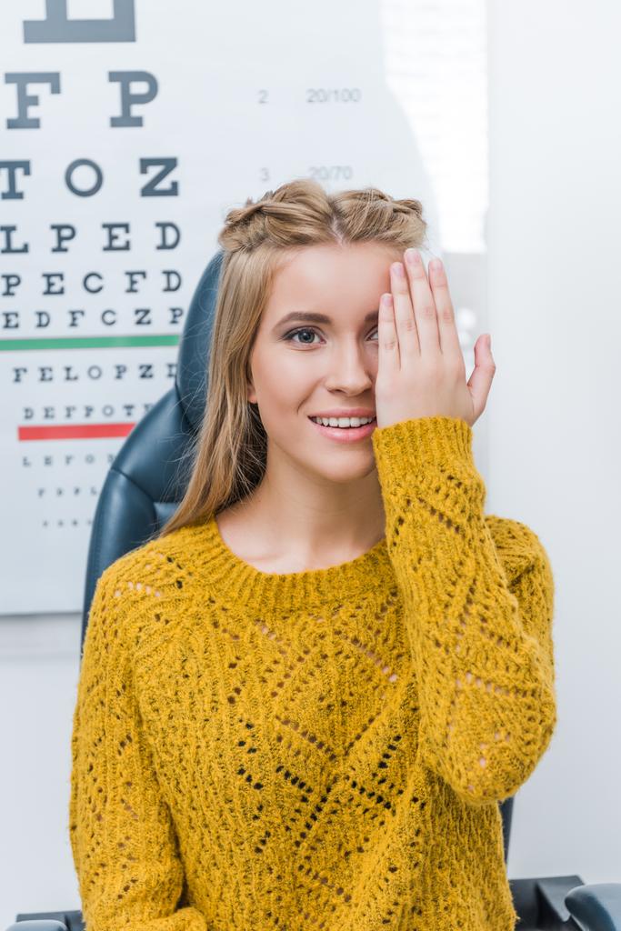 giovane paziente con esame oculistico in clinica con grafico oculare dietro
 - Foto, immagini