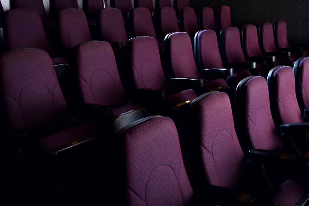 rode zetels in de lege donkere bioscoop - Foto, afbeelding