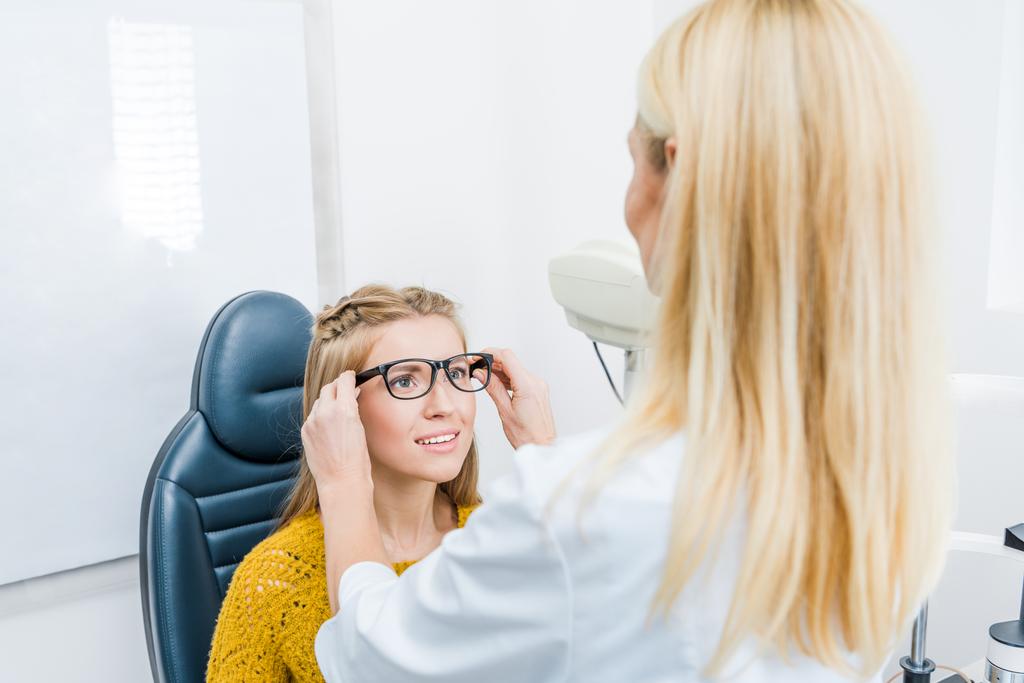 oculiste et patient essayant de nouvelles lunettes en clinique
 - Photo, image