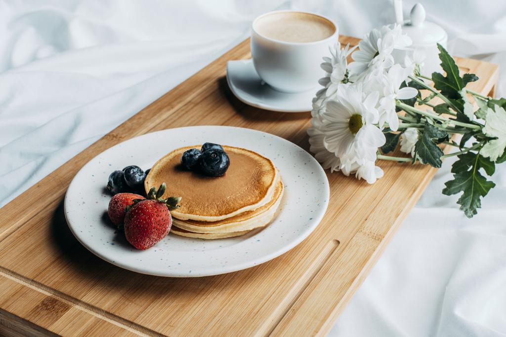 πρωινό στο κρεβάτι με τηγανίτες και καφέ σε ξύλινη θήκη - Φωτογραφία, εικόνα