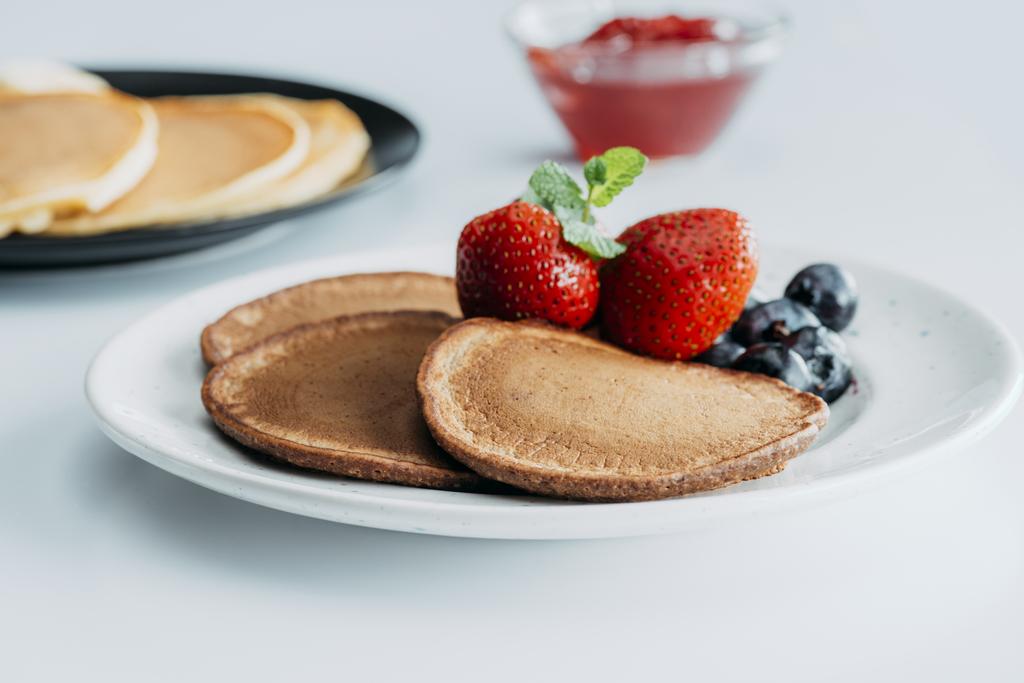 plate with delicious pancakes and berries on white table - Photo, Image